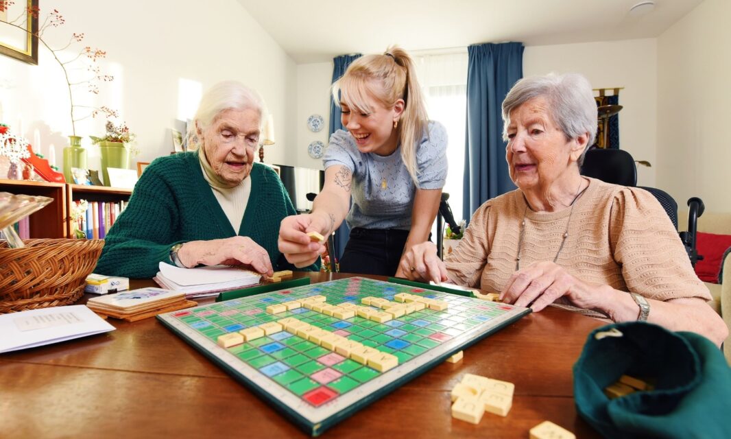 Bewoners en een medewerker spelen een spelletje op de Prinses Irenestraat