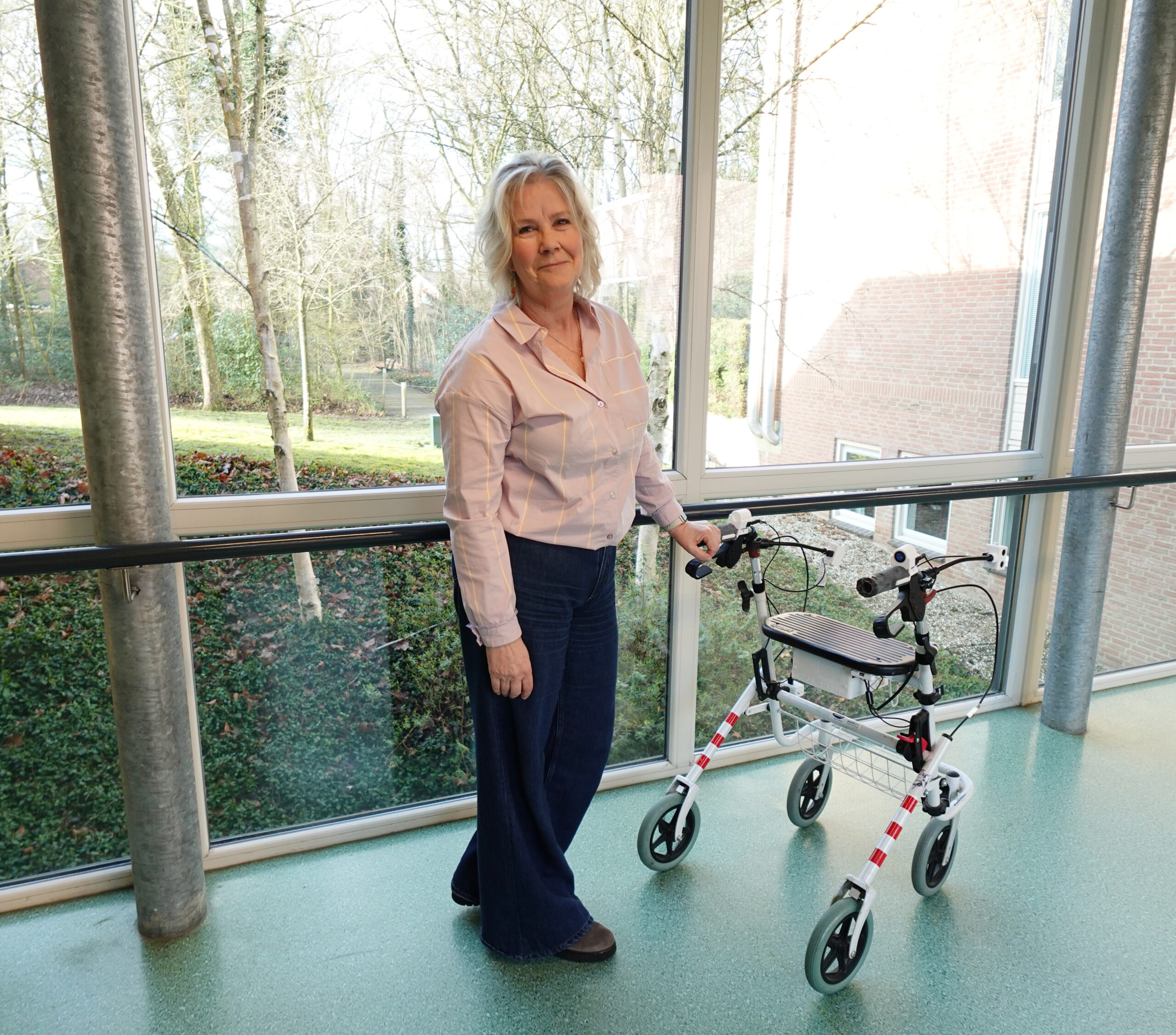Teamhoofd zorg in de gang met de trillende rollator