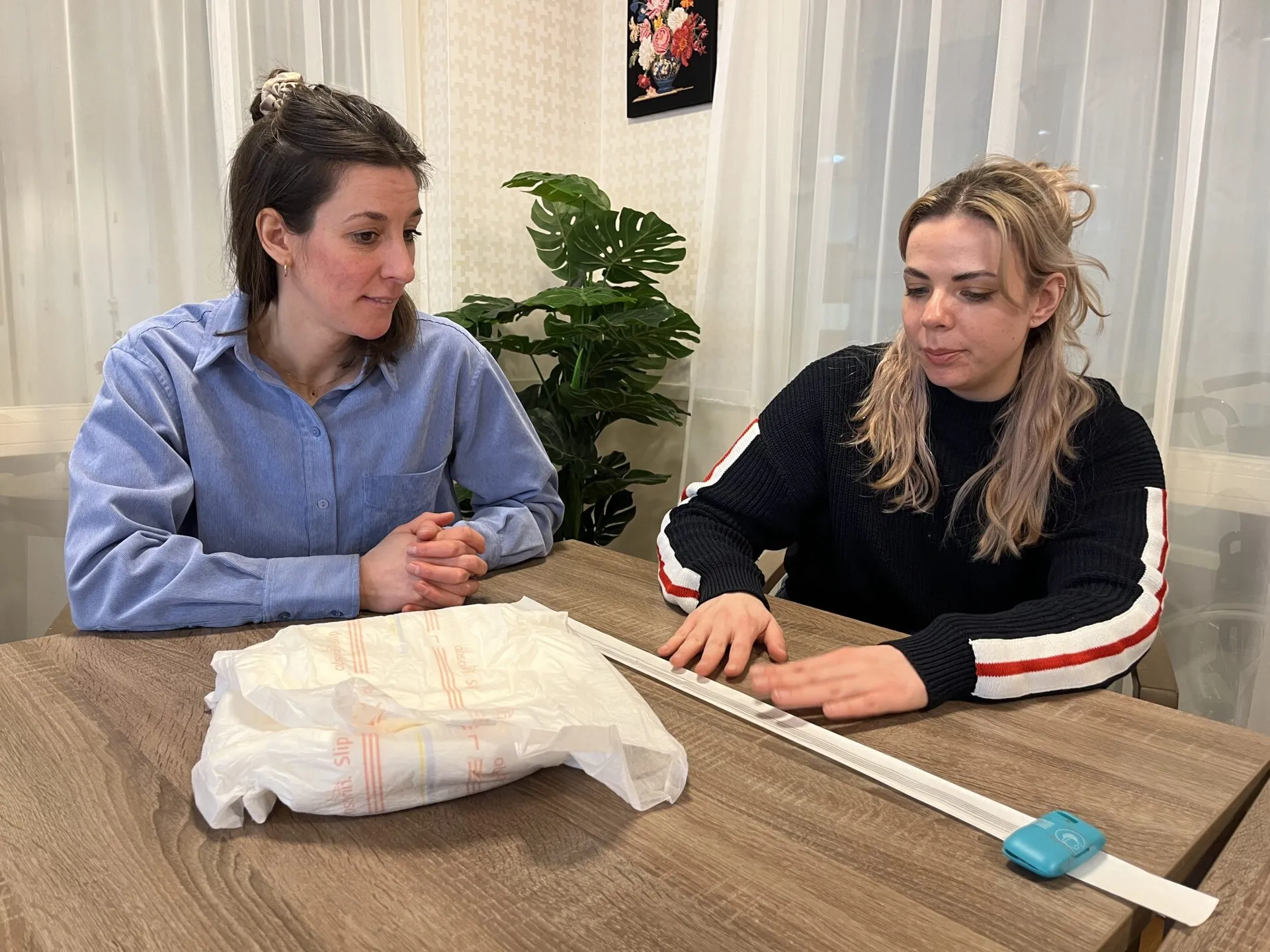 Isabelle en Svenja zitten aan tafel met het slimme incontinentiemateriaal