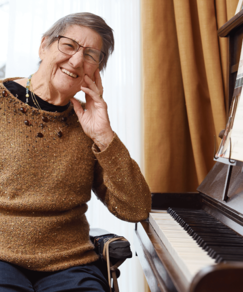 Mevrouw die bij Pleyade woont zit achter de piano