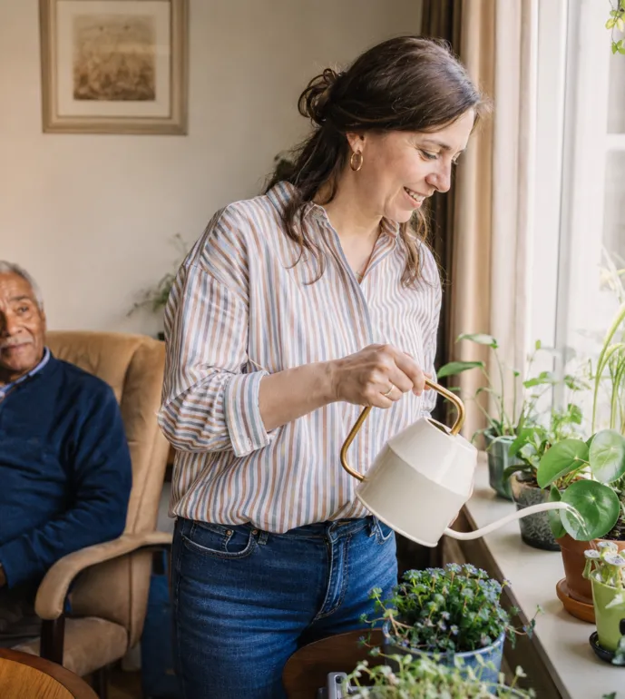 Een zorgprofessional geeft de planten water